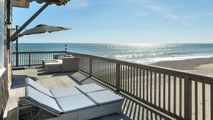 A wooden deck with outdoor seating and a view of the beach. - Oceana: Beachfront Estate, Period Charm, Sleeps 8 (South Kingstown)