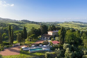 A villa with a swimming pool, surrounded by lush greenery and hills. - Il Poggione 10, Emma Villas (Crocino)