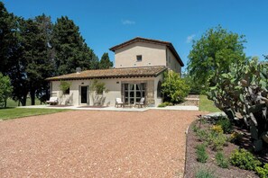 A two-story house with a patio, a gravel driveway, and a garden with cacti. - Il Poggione 10, Emma Villas (Crocino)