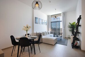 Ein modernes Wohnzimmer mit Essbereich, einer Couch, einem Couchtisch und einer Treppe.