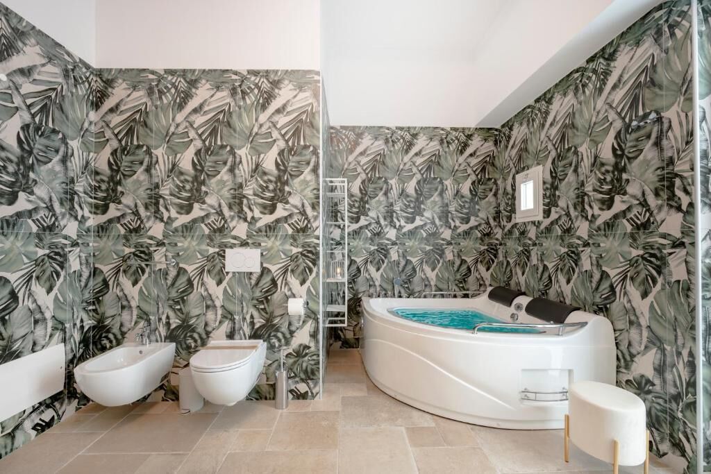 Ein Badezimmer mit Whirlpool, Bidet und Dusche.