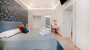 Una camera da letto con un letto, una scrivania e una televisione.
