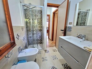 Une salle de bain avec une douche, une baignoire et un lavabo.