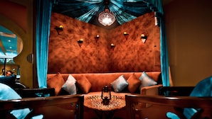 A cozy seating area with a round table, cushioned seating, and a decorative lantern.