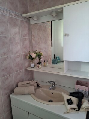 Ein Badezimmer mit Waschbecken, Spiegel und Handtuchhalter.