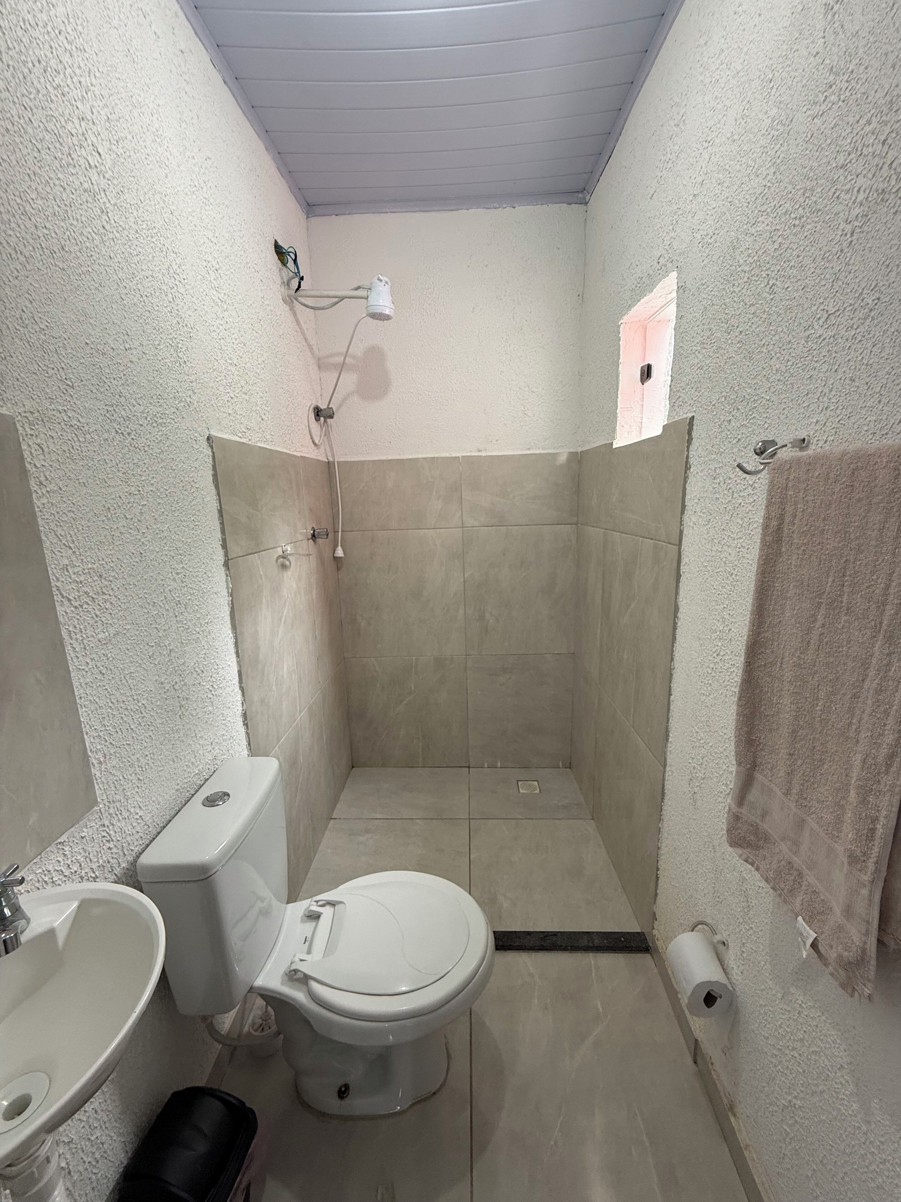 Chuveiro, toalhas de banho, papel higiênico 