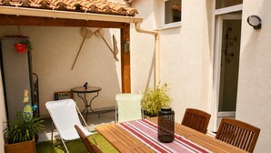 Ein Holztisch mit Stühlen, einer gestreiften Tischdecke und einer dekorativen Vase.
