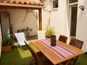 Ein Holztisch mit Stühlen, einer gestreiften Tischdecke und einer dekorativen Vase.