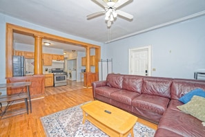 A living room with a leather sofa, wooden coffee table, and patterned rug.