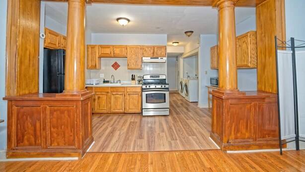 A kitchen with wooden cabinets, a stainless steel oven, and a microwave.