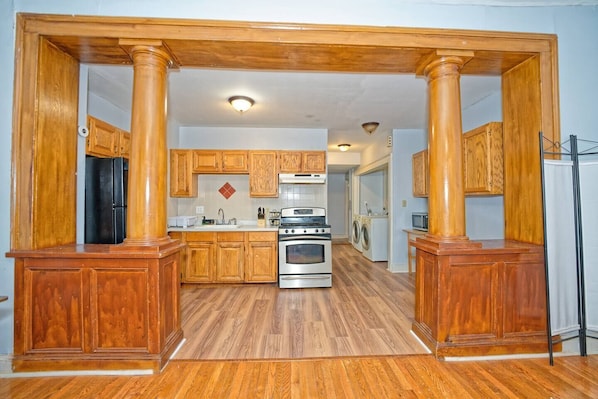 A kitchen with wooden cabinets, a stainless steel oven, and a microwave.