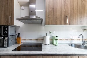 A modern kitchen with a built-in oven, microwave, and induction cooktop.