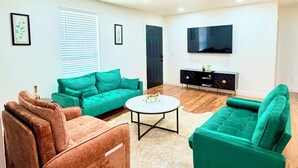 Una sala de estar con un sofá, una mesa de centro y un televisor.