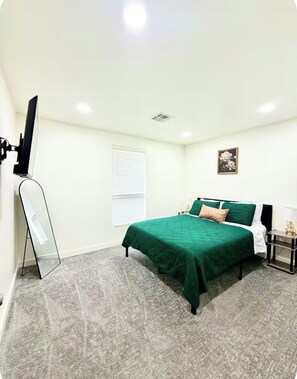 A bedroom with a bed, a standing lamp, a picture frame, and a window with blinds. - Spacious Modern Glam House Minutes To Downtown (Oklahoma City)