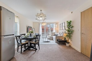 A modern apartment with a dining area, kitchen, living room, and a balcony. - Relocation | Coventry | Early Booking Discount (Coventry)