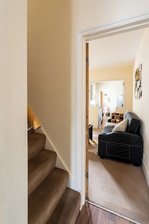 A staircase leading to a living area with a sofa and a coffee table. - Reading | 3 Bedrooms | Relocation | Long Stays (Reading)