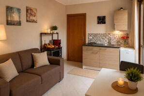 Ein kompakter Wohnbereich mit Sofa, Küchenzeile und Essplatz.