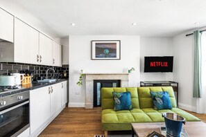 A modern kitchen with white cabinets, a black countertop, and a built-in oven.