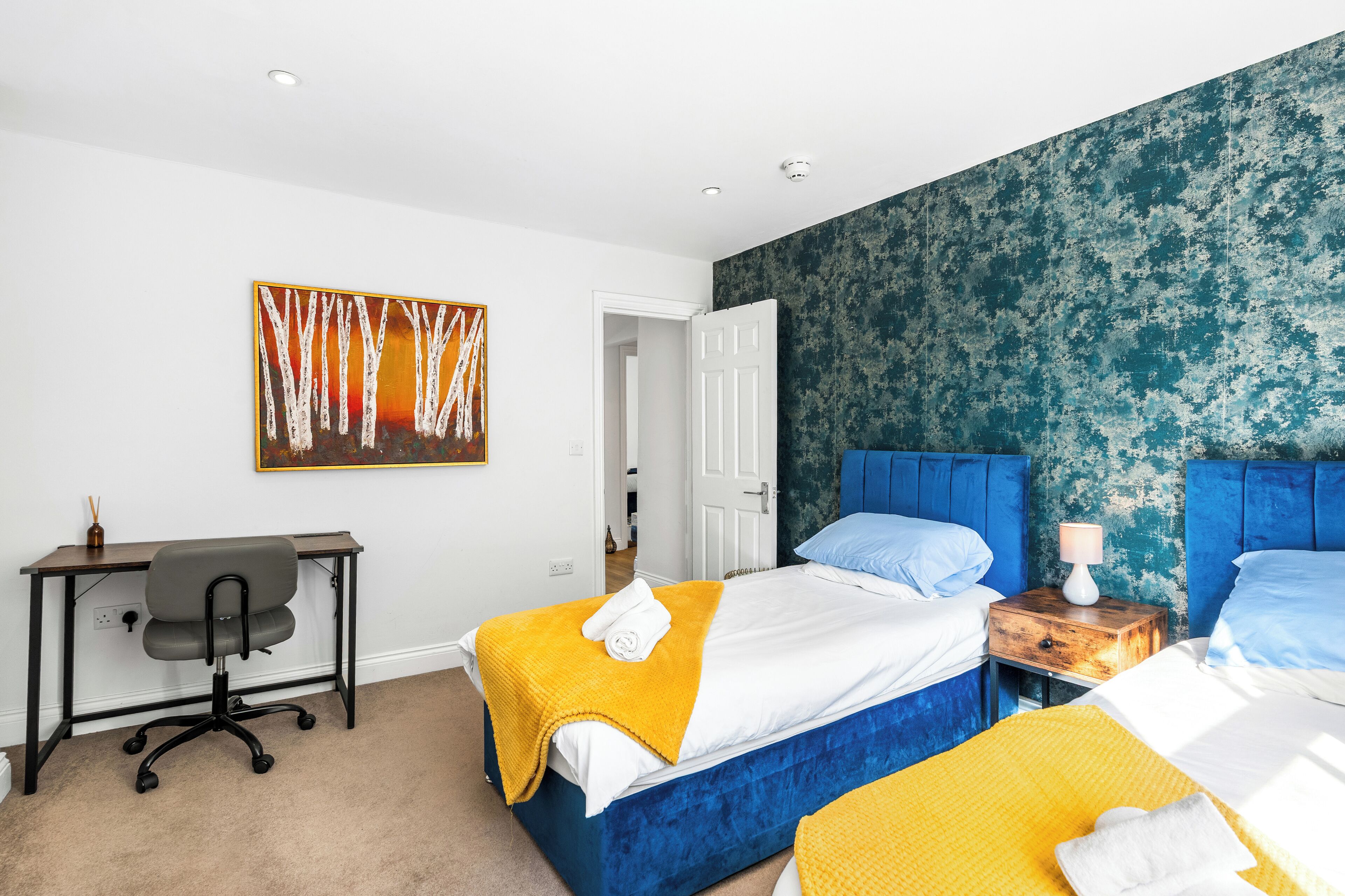 Ein Hotelzimmer mit Bett, Schreibtisch und Stuhl.