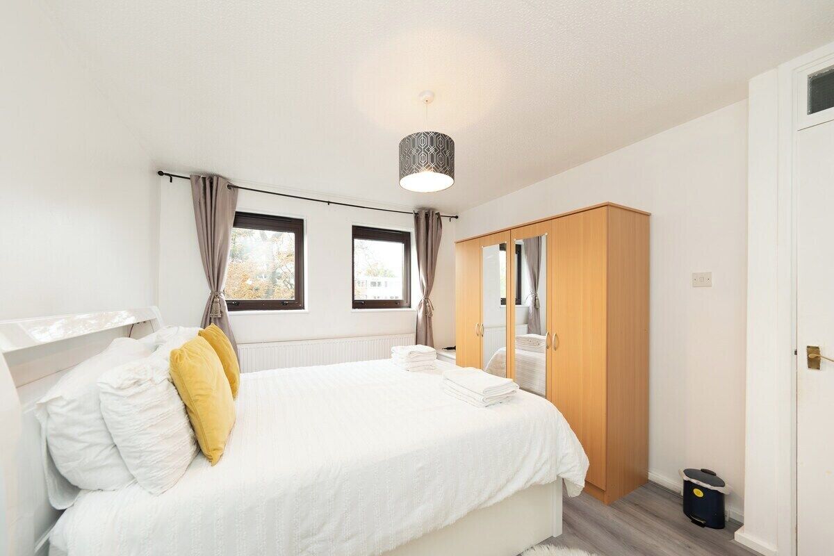 Une chambre à coucher avec un lit, une armoire et une fenêtre.