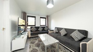 En moderne stue med sofa, sofabord og tv.