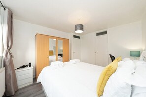 Ein Hotelzimmer mit Bett, Kleiderschrank, Nachttisch und Lampe.