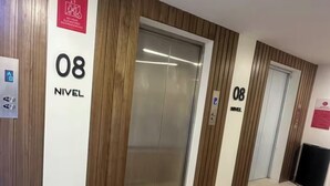 A hallway with two elevators, each marked with '08 NIVEAU' and a red emergency sign. - Nuevo Apt Moderno N811/ 4 People (Tegucigalpa)