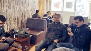 Ein Zimmer mit einer Couch, einem Tisch und einem Laptop.