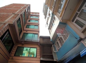 Een meerhoog gebouw met een centrale binnenplaats, grote ramen en een blauwe gevel.