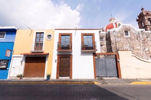 Una hilera de edificios coloridos con balcones, una iglesia y una puerta.