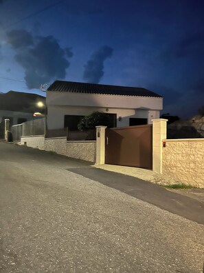 Un immeuble résidentiel doté d’une entrée sécurisée par un portail, d’une allée et d’un mur en pierre.