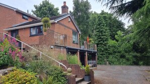 A brick house with a front porch, a staircase, and a gravel driveway. - Quiet, Modern Ground Floor Annex Near Theatr Clwyd (Mold)
