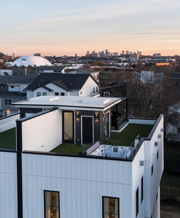 Un bâtiment moderne doté d’un toit plat, de grandes fenêtres et d’un jardin sur le toit.