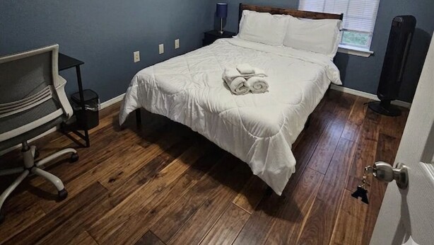 Um quarto com uma cama, uma escrivaninha e uma janela.