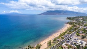 A coastal view with a beach, clear sky, and a mountain in the distance. - Surf Rider, Newly Remodeled, Walk Out Lanai, Ocean View, 2ACs, 350Steps to Kam 1 (Kihei)