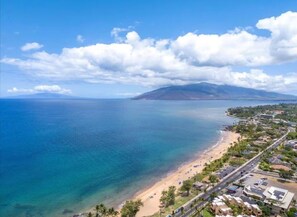 A coastal view with a beach, clear sky, and a mountain in the distance. - Surf Rider, Remodeled, Walk Out Lanai, Ocean View, 2ACs, 5 Min Walk to Kam 1 (Kihei)