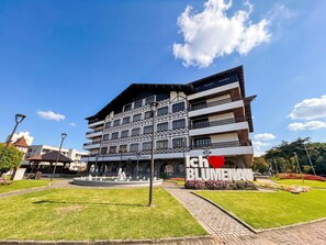 A multi-story building with a prominent sign reading 'ICH BLUMENHAUS.' - Apt with A/C near FURB, parking, pet friendl (Blumenau)
