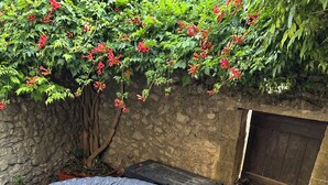 A spa hot tub, a stone wall, and a wooden door. - Small 4 person self-catering apartment in LEDENON - Entire apartment (Lédenon)