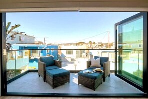 A balcony with wicker furniture and a view of buildings. - Sleeps 20 Walk to Beach 2 Side-by-Side Homes (San Diego)
