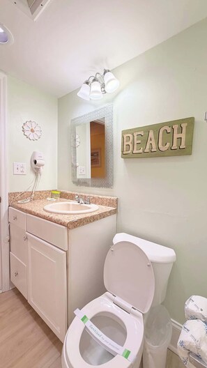 Ein Badezimmer mit Waschbecken, Toilette und Spiegel.