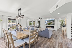 A spacious living area with a dining table, sofa, and TV. - Themed Luxury Retreat | Pool, BBQ & Arcade (Gilbert)