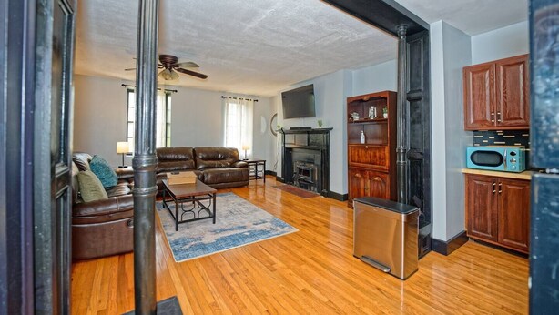 A living room with a fireplace, wooden cabinets, a sofa, and a television.