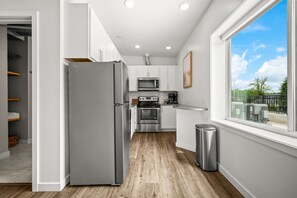 Una cocina moderna con refrigerador de acero inoxidable, microondas, horno y lavaplatos.