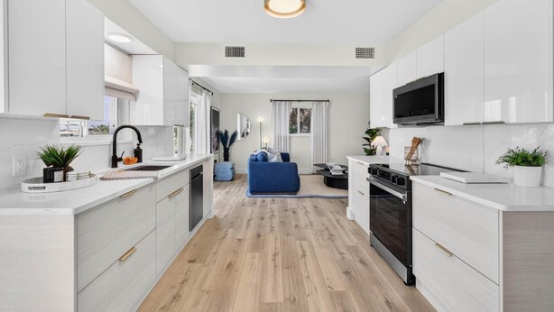 A modern kitchen with white cabinets, a built-in oven, and a microwave. - Bayfront Waterview Newly Upgraded Condo Clearwater Beach (Clearwater)