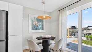 A modern kitchen with a dining area, a large window with a view of the outside, and a ceiling light fixture. - Bayfront Waterview Newly Upgraded Condo Clearwater Beach (Clearwater)