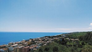Eine Küstenstadt mit Gebäuden, wolkenlosem Himmel und dem Meer.