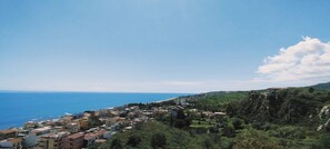 A coastal town with buildings, a clear sky, and the sea.