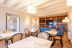 Une chambre d’hôtel moderne dotée d’un coin repas, d’un canapé et d’une télévision.