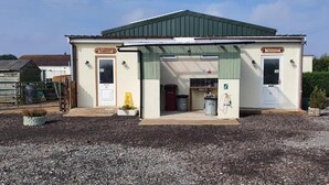 Un petit bâtiment doté d’un toit végétalisé, d’une porte et d’une fenêtre.