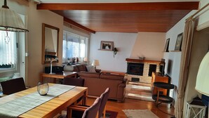 Un accogliente soggiorno con camino, arredi in legno e un'area pranzo.